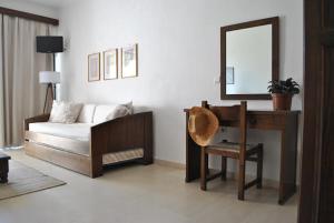 a living room with a couch and a mirror at Thalassa Studios in Loutrá Kounoupélli