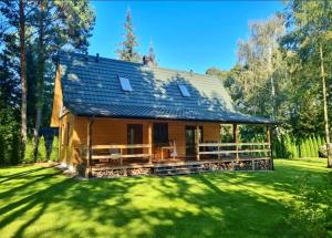 a log cabin in the middle of a green yard at Leśne zacisze nad Narwią in Ostrykół Włościański
