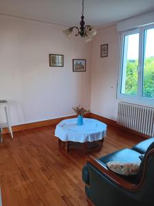 ein Wohnzimmer mit Tisch und Couch in der Unterkunft Maison de vacances in Lannion