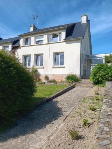 ein weißes Haus mit einem Weg davor in der Unterkunft Maison de vacances in Lannion