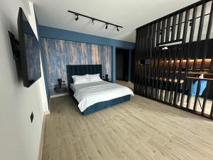 a bedroom with a white bed and a wooden floor at Studio Black Sea- Infinity Pool & Spa Resort in Mamaia Nord