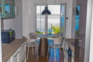 kuchnia ze stołem i krzesłami oraz balkon w obiekcie Apartment Vincent with beautiful sea view terrace w mieście Klenovica +37 zdjęć