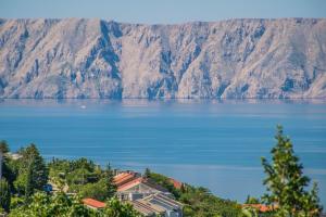 widok na jezioro z górami w tle w obiekcie Apartment Vincent with beautiful sea view terrace w mieście Klenovica