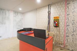 una oficina con un escritorio rojo con un ordenador portátil. en Hotel O DSG Residency, en Faridabad