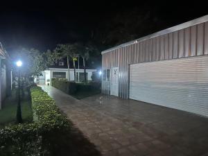 a building with a fence and a garage at night at Thompson House in Orotina