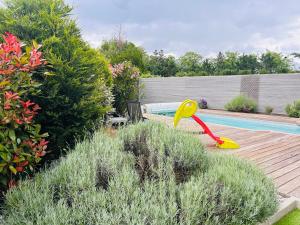 a backyard with a swimming pool and a yellow shovel at Maison T5 avec piscine T5chambres Annecy in Annecy