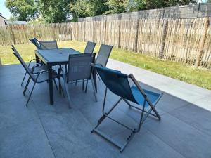 a group of chairs around a table on a patio at Charmante maison neuve au cœur de Matignon in Matignon