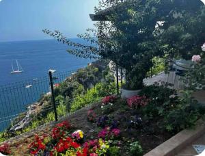 a garden with flowers and a view of the ocean at Casa Pappalardo in Ravello