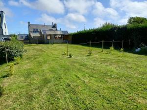 un ampio cortile con una casa e una recinzione di Gîte & studio de l'Holothurie a Plouguerneau