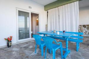 a blue table and chairs in a room with a window at Studio Evaggelia Sea View in Skala Marion