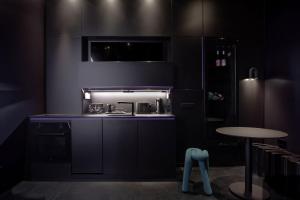 a black kitchen with a sink and a table at Your very unique private spa in Berlin Kreuzberg in Berlin