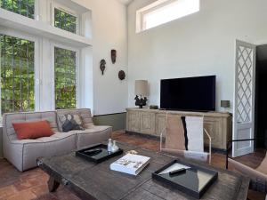 TV a/nebo společenská místnost v ubytování Le Clos Saint-Sif, 4 BR, air conditioning, pool + 37 fotografií