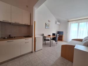 a kitchen and living room with a bed and a table at Apartments and Rooms Saric in Jadrija