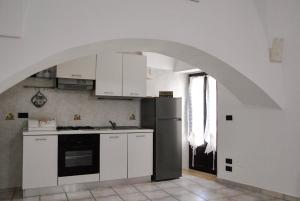 una cucina con armadi bianchi e un arco di Dimora Nuccio a Martina Franca Altre 17 foto