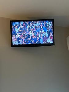 a flat screen tv hanging on a wall at CHAMBRE COCOONING centre ville des Sables D'Olonne quartier Gare Saint Michel située à 1 kilomètre du remblai in Les Sables-d'Olonne