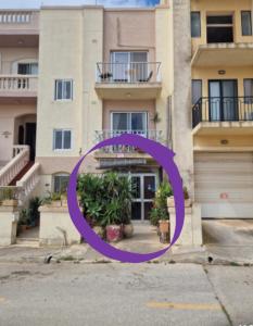 a building with a purple circle in front of it at sunrise flats in Mellieħa