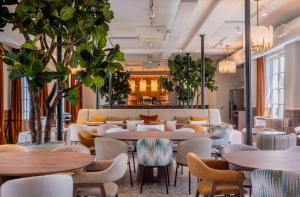 a lobby with tables and chairs and plants at L'Horloge - Appart'Hotel proche de Disneyland in Montévrain