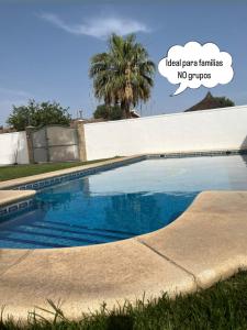 a swimming pool in front of a house with the words ideal yard families no cr at Sunset Palm in El Puerto de Santa María