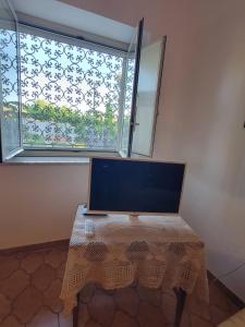a table with a laptop on it in front of a window at Etna view Villa Letizia a Taormina in Taormina