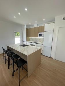 a kitchen with a large island with chairs around it at Sunset Palm in El Puerto de Santa María