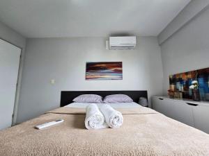 a bedroom with a bed with towels on it at Apê à 5min da Praia com Piscina na Coberftura in Maceió +12 photos