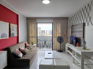 a living room with a couch and a table at Apê à 5min da Praia com Piscina na Coberftura in Maceió