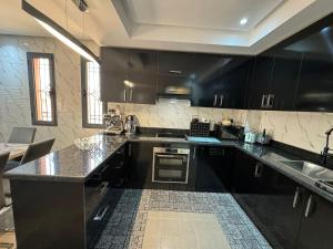 a kitchen with black cabinets and stainless steel appliances at Maison Privée avec Sauna Marrakech in Chouiter +15 photos