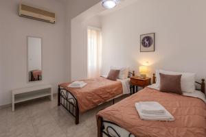 a hotel room with two beds and a mirror at STEGNA REA Seaside Apartment in Archangelos