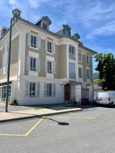 a large building with a white car parked in a parking lot at Villa Anita -centre ville -parking privé -wifi in Barcelonnette