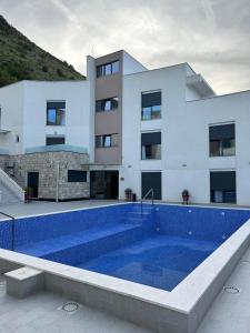 a house with a swimming pool in front of a building at I&I Apartment in Igalo +1 photo