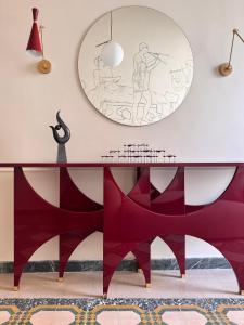 a dining room with a table and a mirror at Academia Apulian Suites - Marsia's Apartment in Mola di Bari