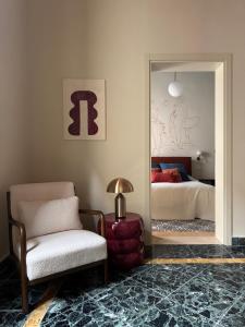 a room with a mirror and a chair and a bed at Academia Apulian Suites - Marsia's Apartment in Mola di Bari