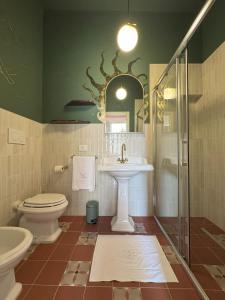 a bathroom with a toilet and a sink and a shower at Academia Apulian Suites - Marsia's Apartment in Mola di Bari +9 photos