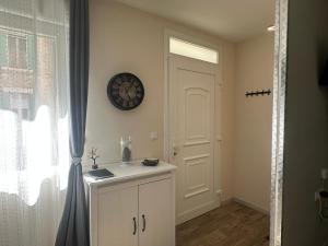 a room with a white door and a clock on the wall at La Loge du Théâtre in Orange