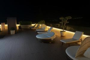 a row of lounge chairs on a deck at night at Biser Igala in Herceg-Novi