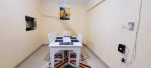 Zimmer mit einem weißen Tisch und 2 Stühlen in der Unterkunft Palm Terraces in Mombasa