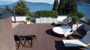 a patio with chairs and tables and a view of the water at Biser Igala in Herceg-Novi