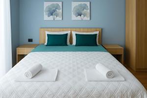 a bedroom with a bed with two towels on it at Biser Igala in Herceg-Novi