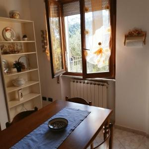 a dining room with a wooden table and a window at La Collina in Riccò del Golfo di Spezia