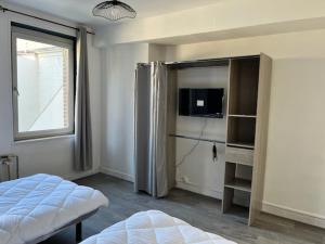 a bedroom with a bed and a tv and a window at L escale in Givet
