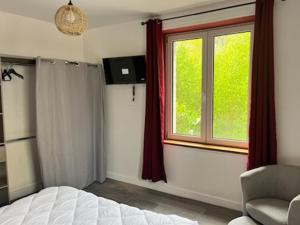 a bedroom with a bed and a window and a chair at L escale in Givet