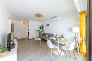 a living room with a table and chairs and a couch at LA PERLE 2 P Terrasse Vue Mer 1min Plage Clim in Roquebrune-Cap-Martin