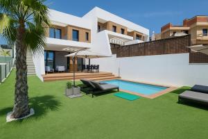 a villa with a swimming pool and a palm tree at VILLA VERAMAR in Finestrat