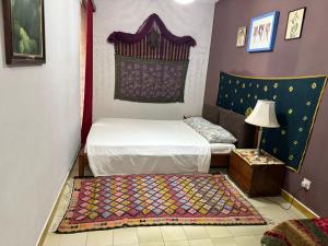 a small bedroom with a bed and a rug at sunrise flats in Mellieħa