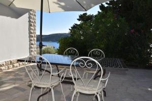 een tafel en stoelen met een parasol op een terras bij Family House Stara Novalja in Stara Novalja