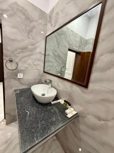 ein Badezimmer mit Waschbecken und Spiegel in der Unterkunft Marina Suites Lahore in Lahore