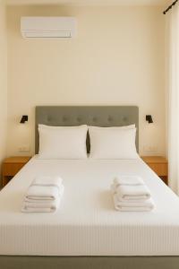 a bedroom with a white bed with two towels on it at Diamond D2 Iraklitsa in Iraklitsa +29 photos