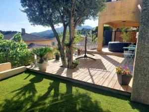 a garden with a tree on a wooden deck at Chambre indépendante avec terrasse privative in Le Revest-le-Eaux