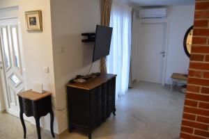 een kamer met een zwarte dressoir en een televisie. bij Family House Stara Novalja in Stara Novalja