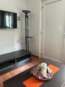 a living room with a table with a candle and a television at Casa Familiar con barbacoa in Finisterre